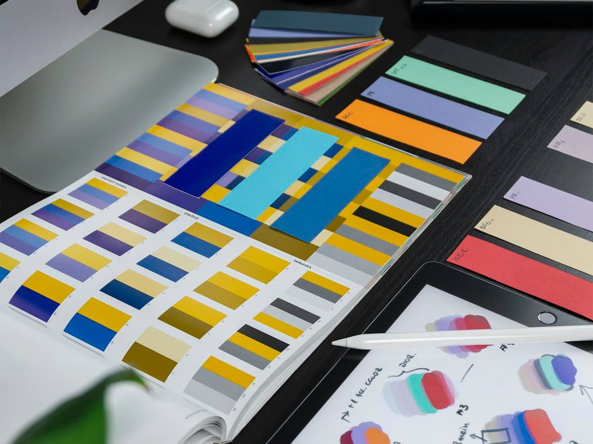 Color palette swatches and a tablet with design sketches on a desk